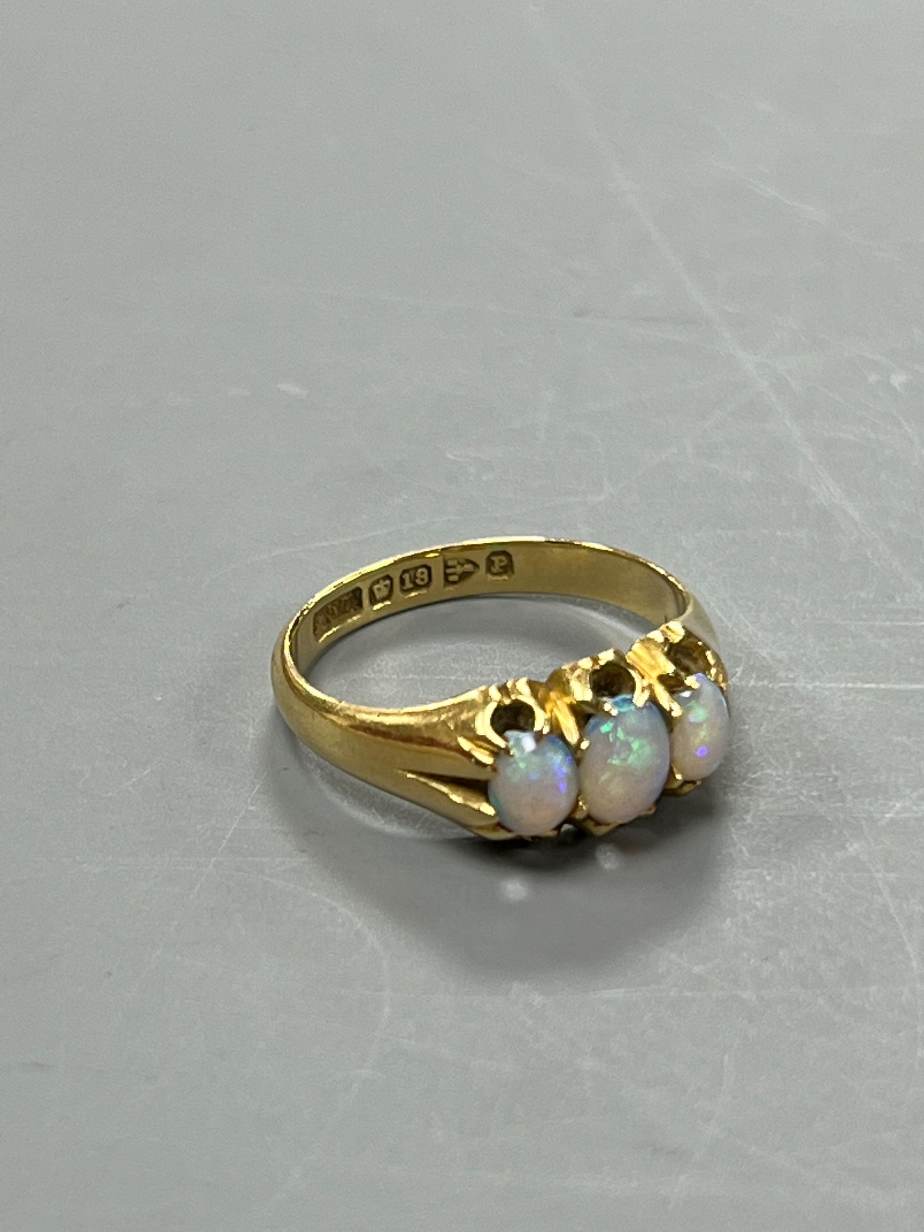 A late Victorian 18ct gold and claw set three stone white opal ring, size M, gross weight 4.1 grams.